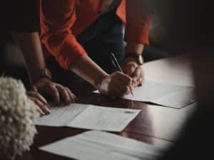 Two Sets of Hands Signing Documents in Expungement Case