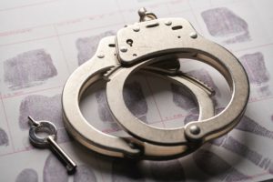 Handcuffs Sitting on Thumbprinted Paper for Sex Crime Case